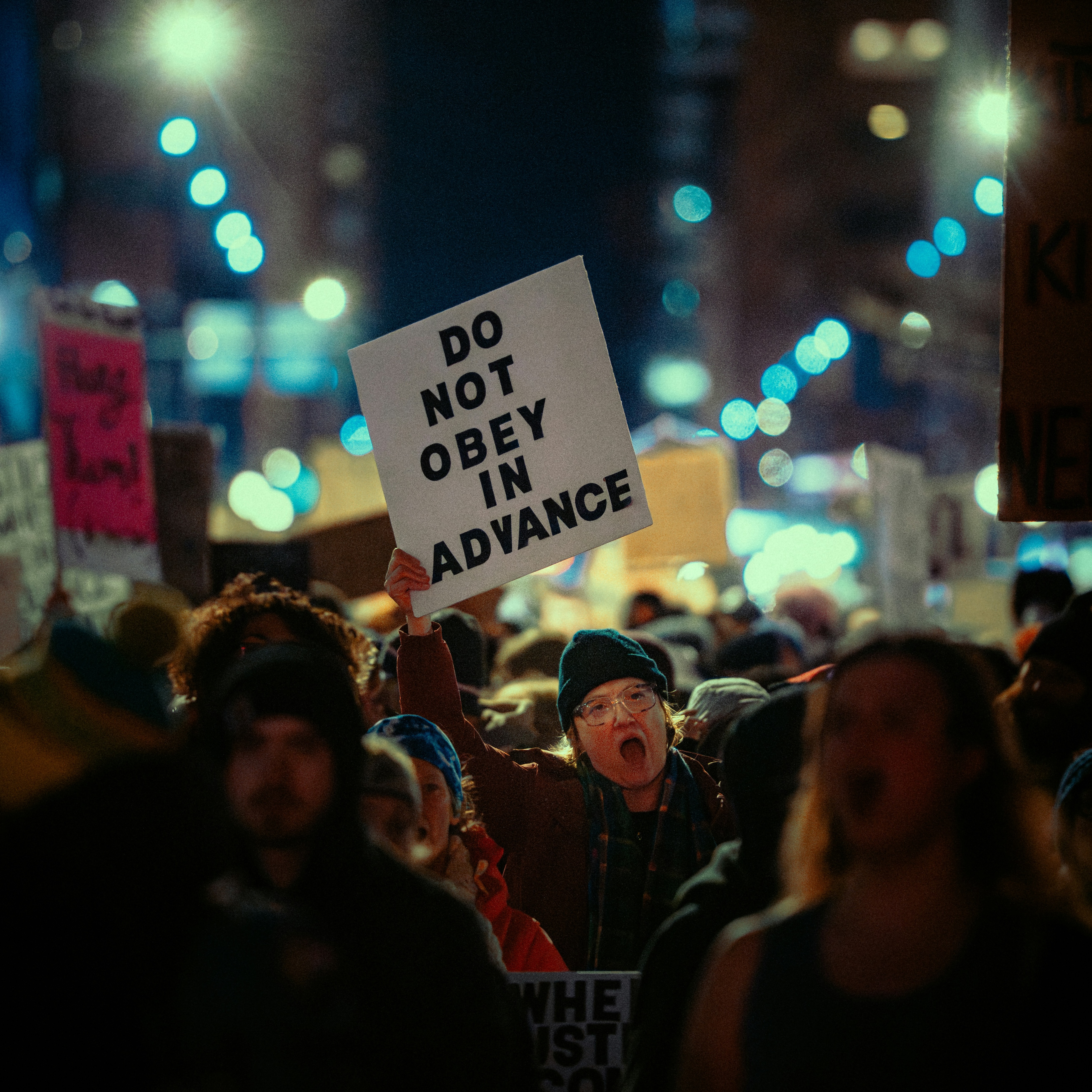 Protestor holding a sign that reads "do not obey in advance" in Minneapolis in 2026